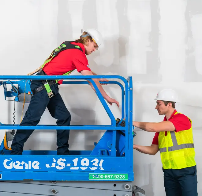 Two restoration experts working together on a lift.