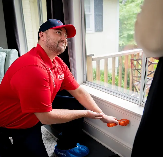 A Rainbow Restoration expert checks for water damage in a wall at a Lexington, NC, home using a moisture meter.