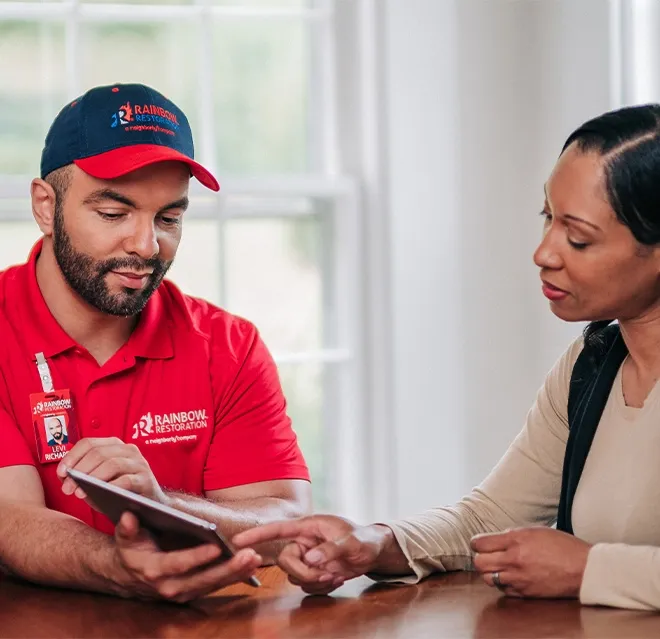 A Rainbow Restoration representative discusses property restoration services with a homeowner in Gaston, SC.