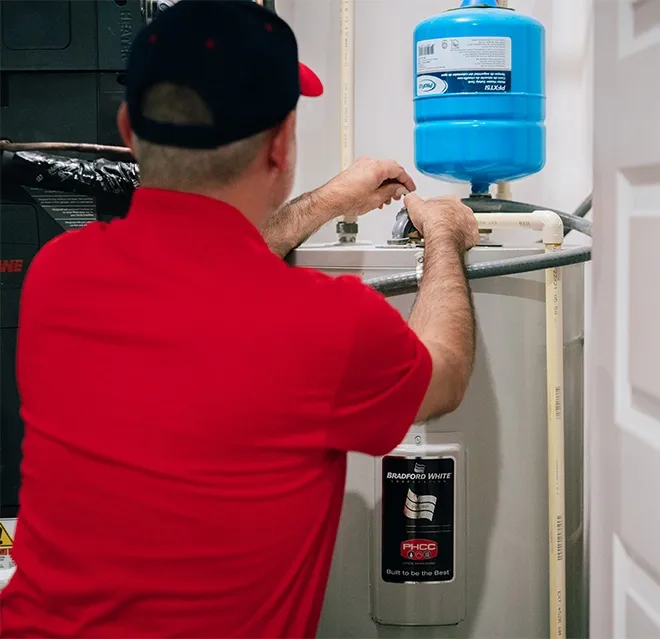 A Rainbow Restoration expert checks for water damage near a water heater at a Mapleton, ND, home.