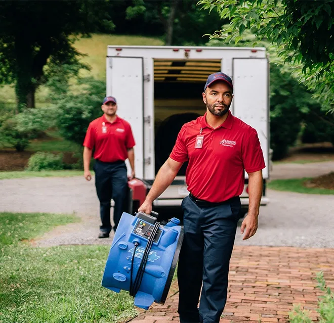 A team from Rainbow Restoration carries equipment into a property after responding to a call for restoration services in Modesto, CA.