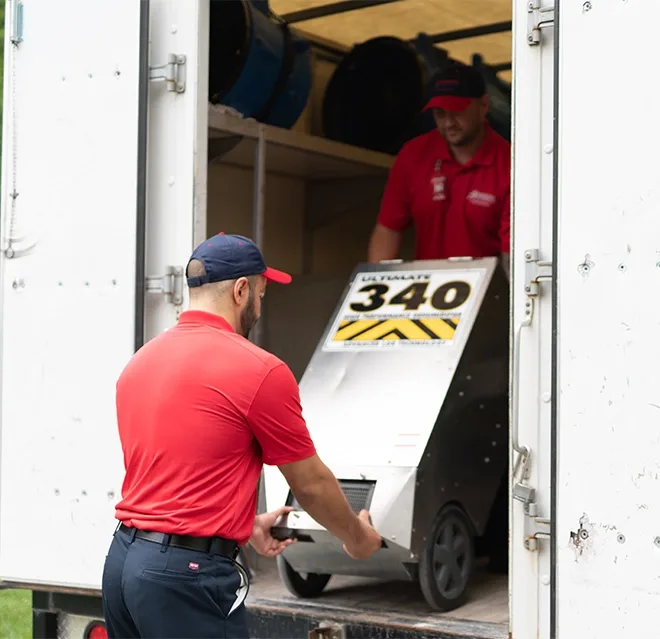 Rainbow Restoration technicians unload water damage equipment at a residential property damaged by water in Eastlake, CO.