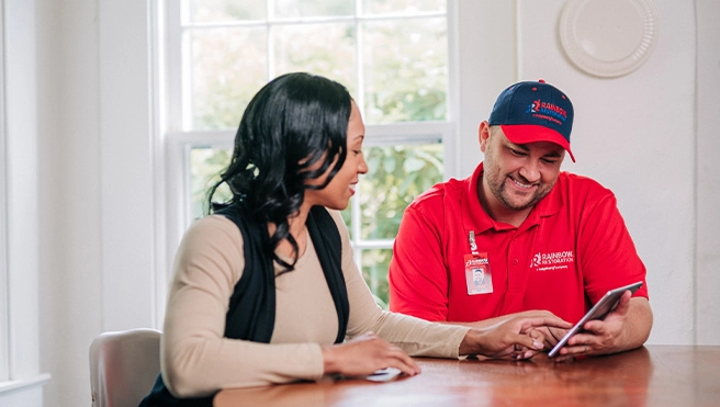 A Rainbow Restoration representative discusses insurance claims with a homeowner in Dickinson, TX.