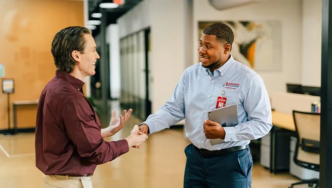 A Rainbow Restoration representative shaking the hand of a property owner at a commercial property in Midlothian, VA.