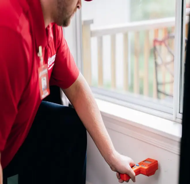 Rainbow Restoration professional checking humidity levels in a home.