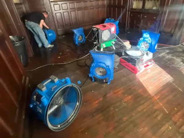 Water restoration equipment dries hardwood floors inside an older Jonesborough home after spring flooding caused indoor water damage.