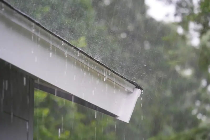 Heavy fall rainfall coming down on a home&rsquo;s gutters